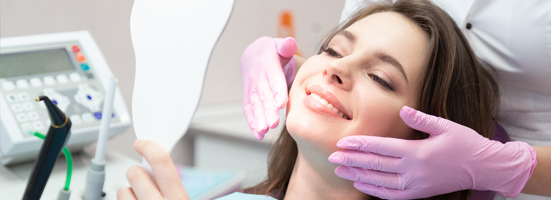 A woman receiving dental care, with a dentist using a drill on her tooth.