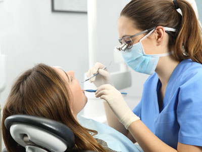 A dental hygienist performing a cleaning procedure on a patient in a modern dental office.