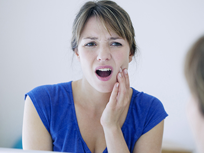 The image depicts a woman with her hand on her face, expressing surprise or concern.